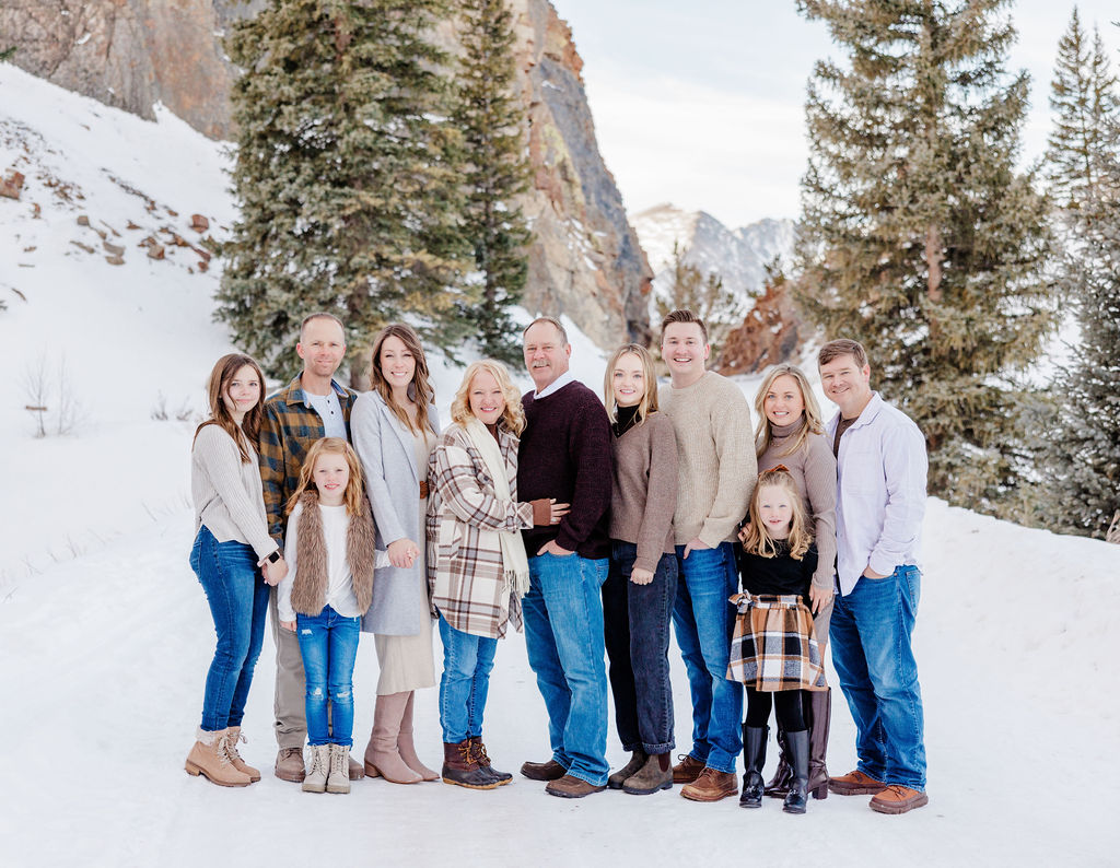 A large extended family stands together and smiles with 3 generations during family hikes in breckenridge