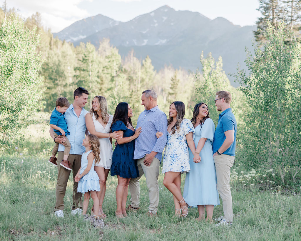 A happy extended family smile and hug each other in a mountain trail