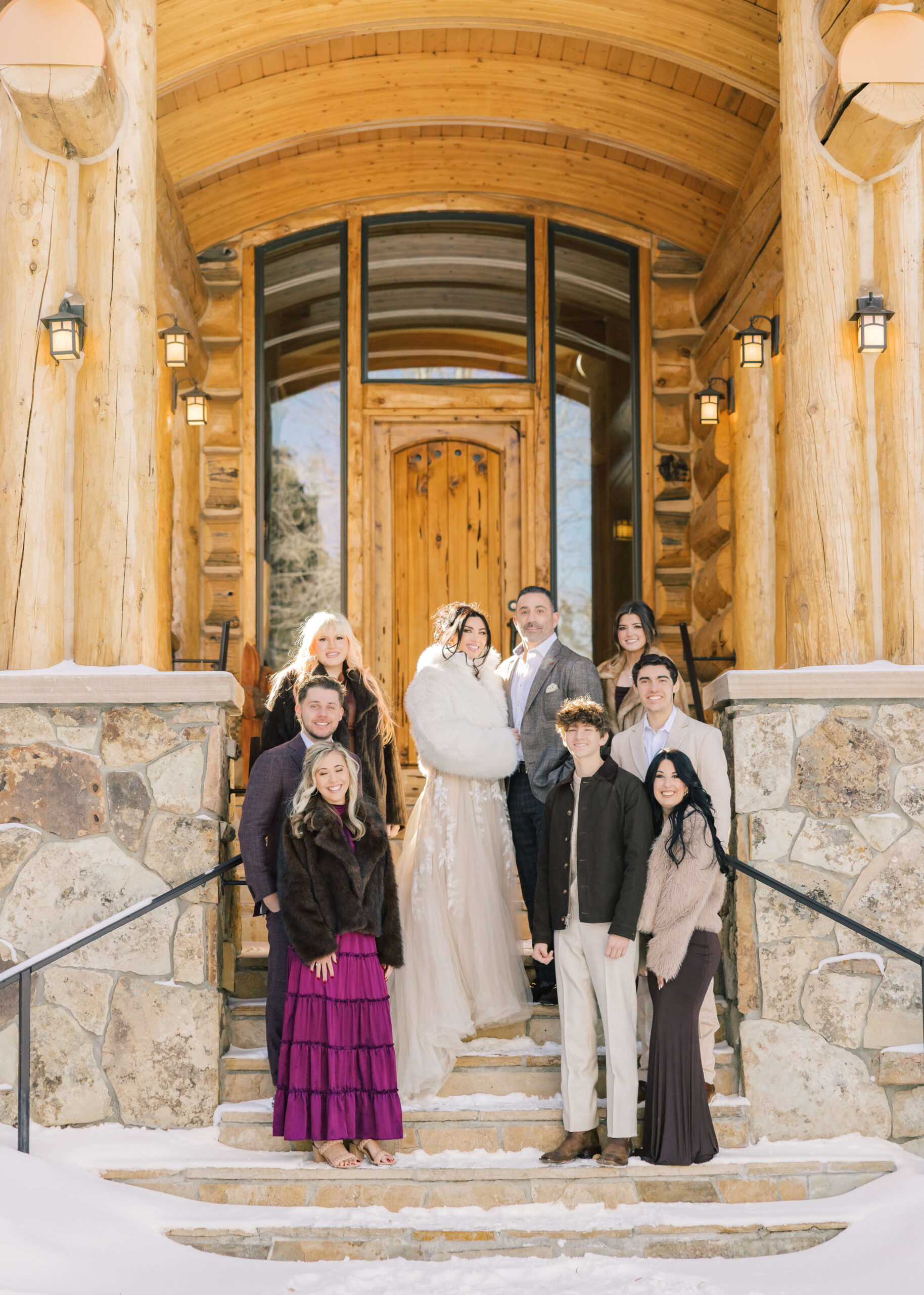 Newlyweds stand on the front steps of one of the Breckenridge Ski Resort Condos with their friends and family