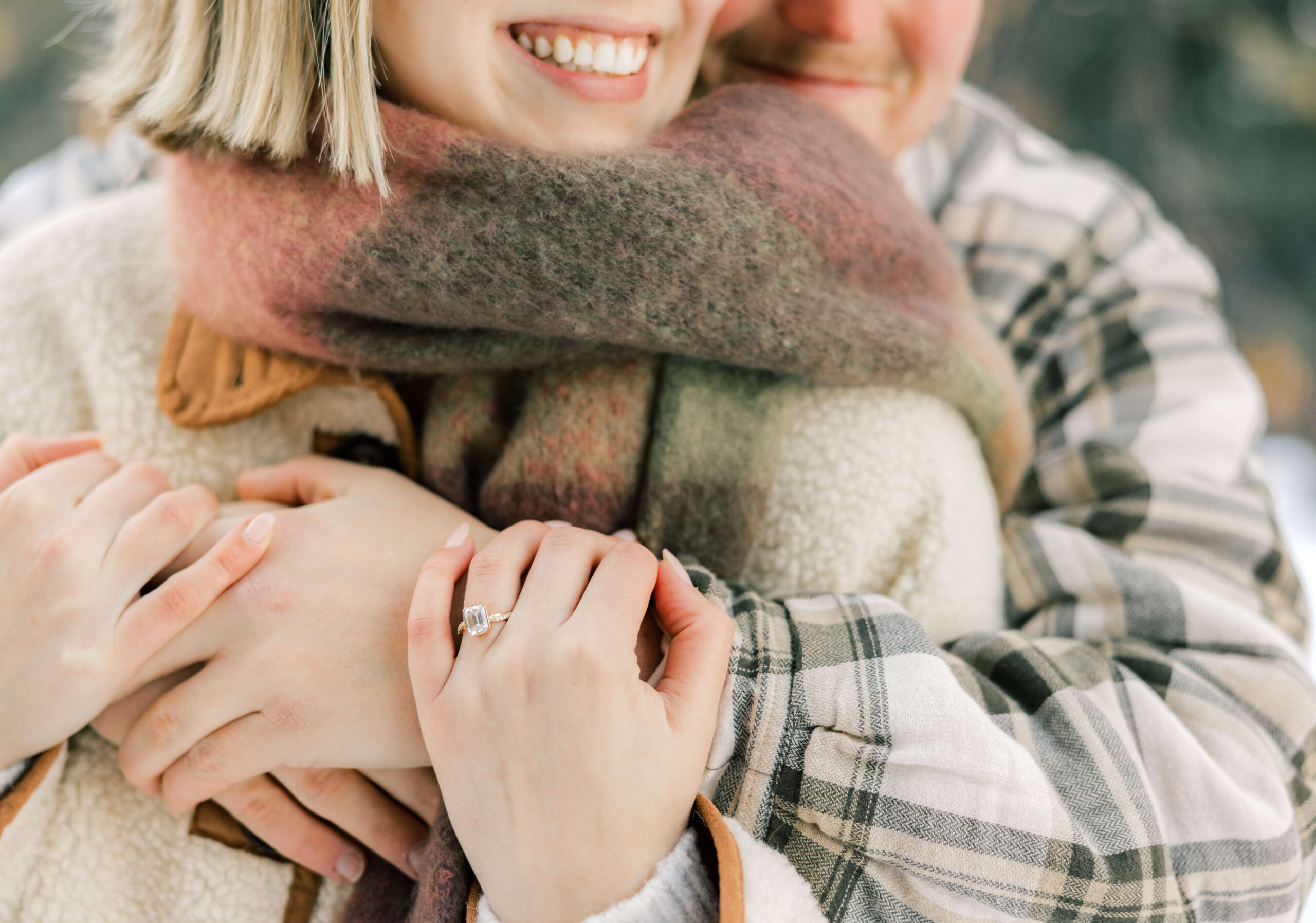 Details of a happy engaged couple hugging with the engagement ring