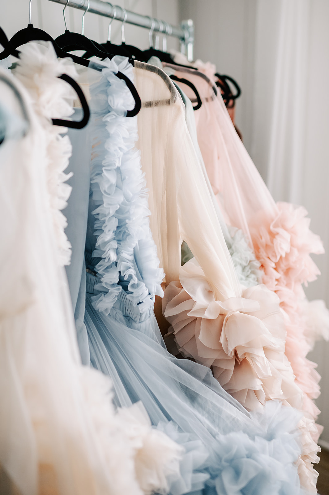 Details of multiple tulle maternity gown hanging on a rack